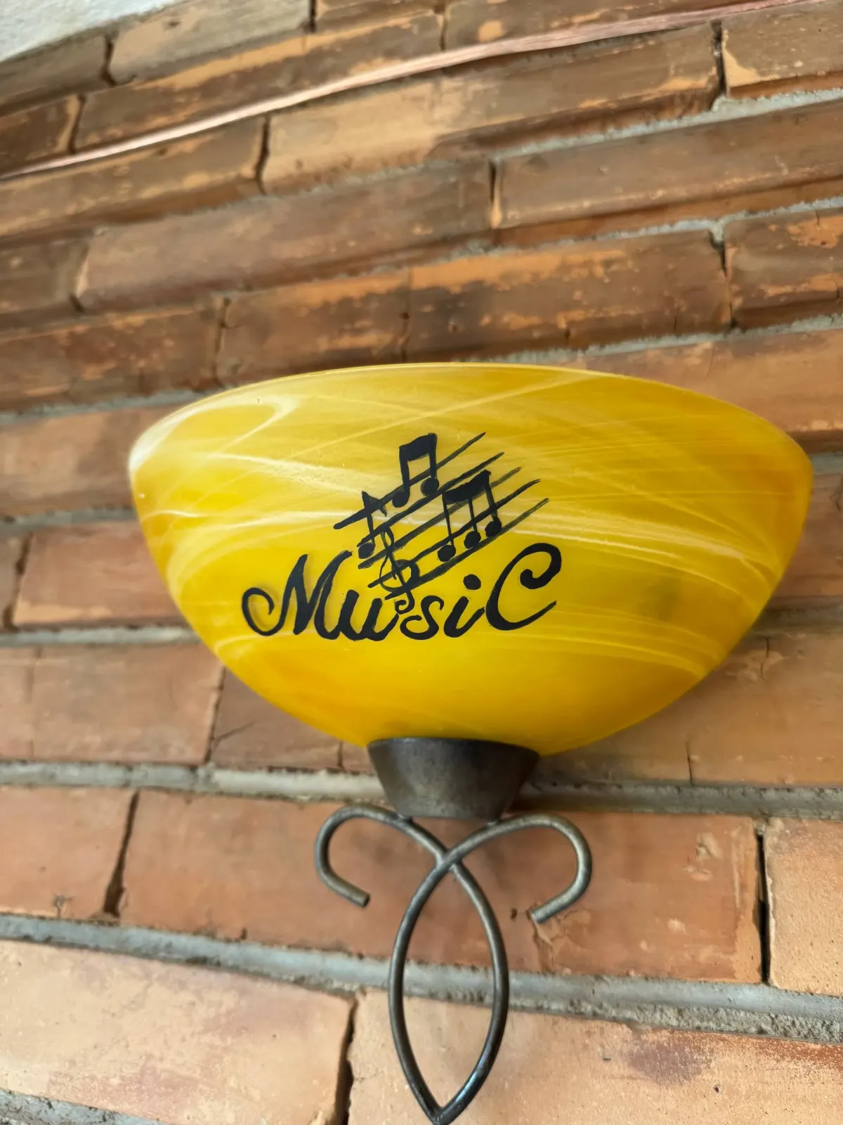 Lampa galbenă pictată cu portativ și note muzicale.